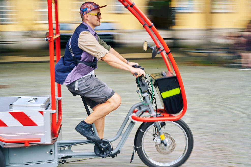 Lastenfahrrad mit Fahrer auf dem Karlsplatz